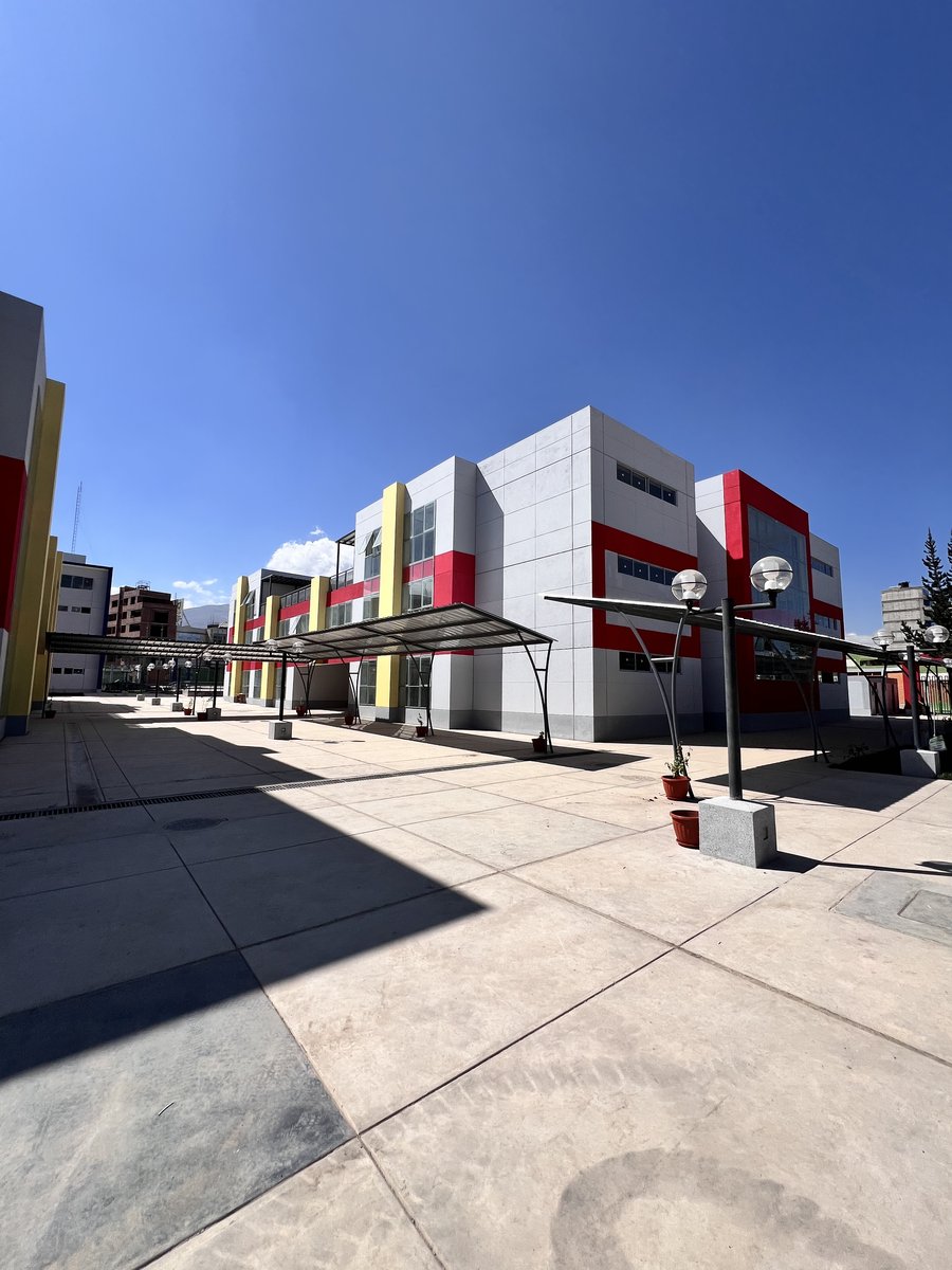 Patio interior del I.E. Coronel Mariscal Castilla con edificios rojos, blancos y amarillos