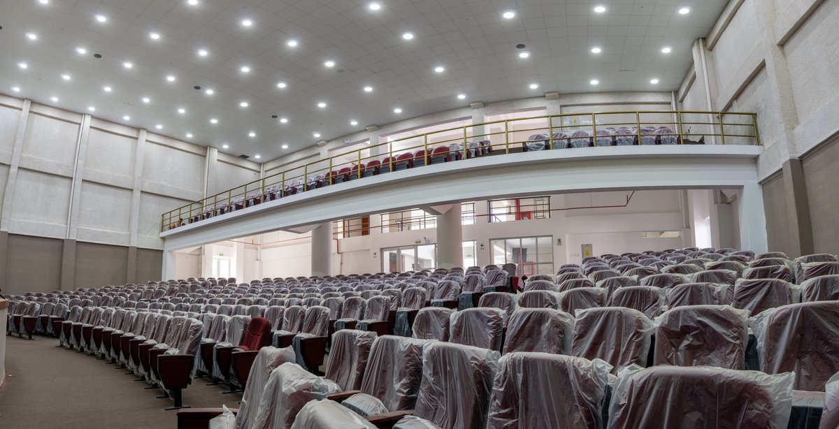 Auditorio con butacas protegidas por fundas, platea y balcón.