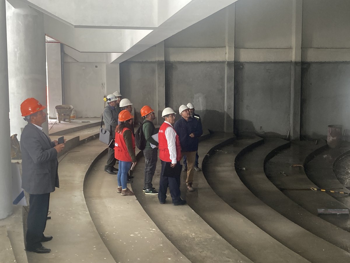 Equipo con cascos revisando el auditorio en construcción.